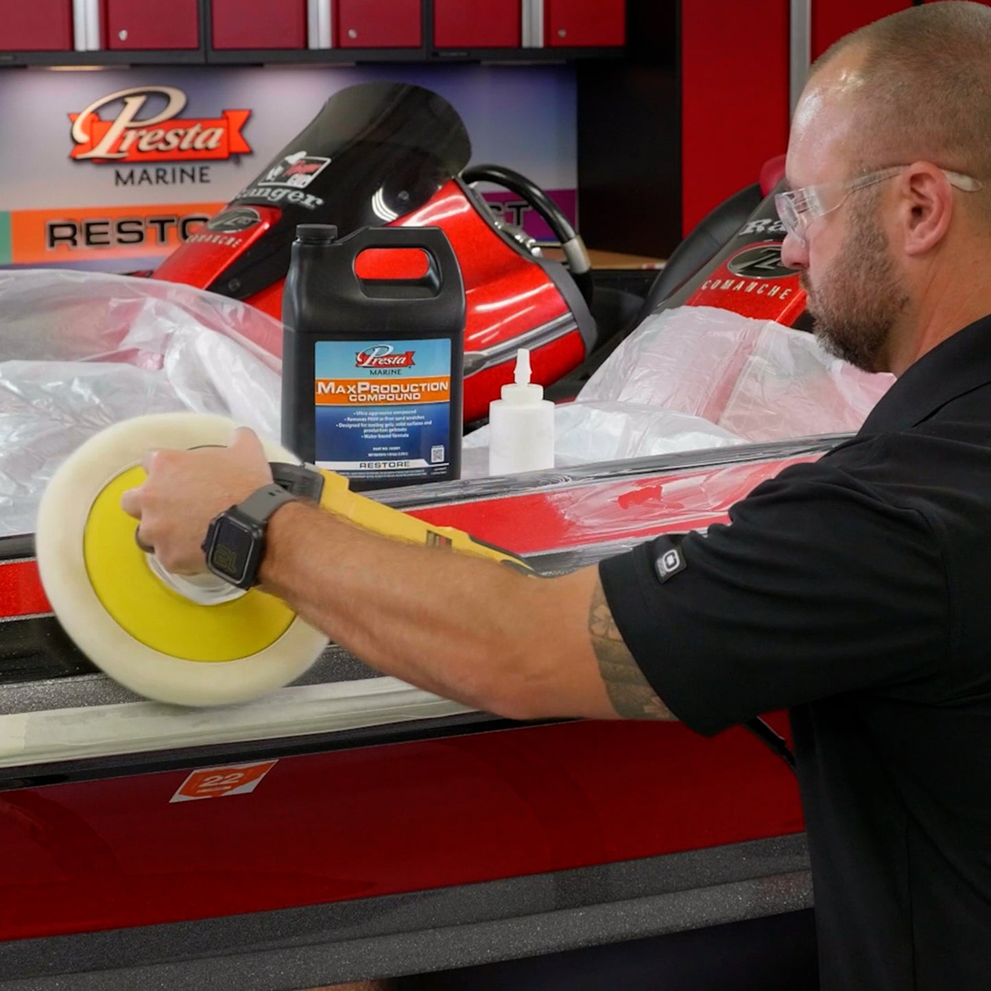 A person using a white and yellow Polishing Pad to polish a red boat