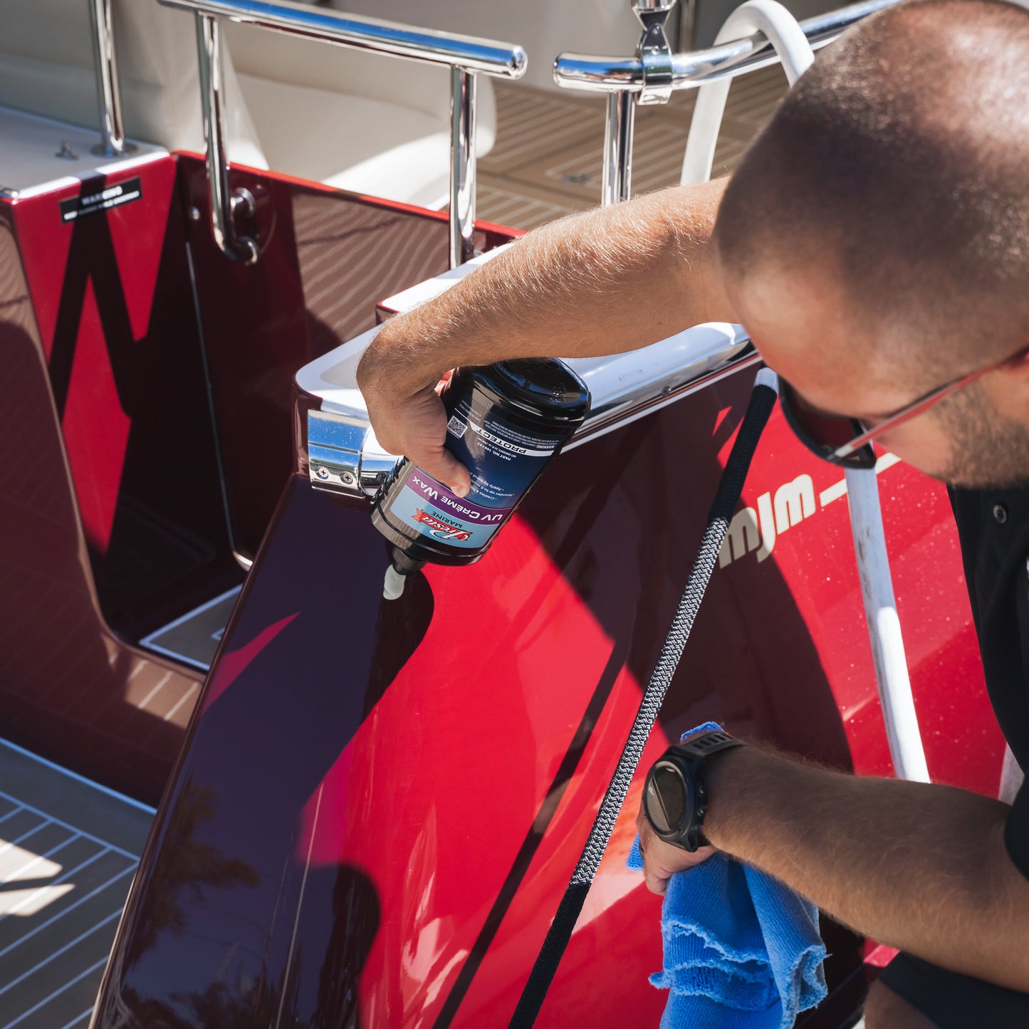 a person spraying UV Crème Wax can on a boat